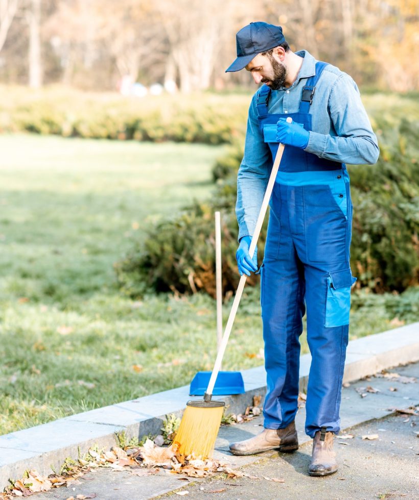 Cleaner sweeping leaves outdoors